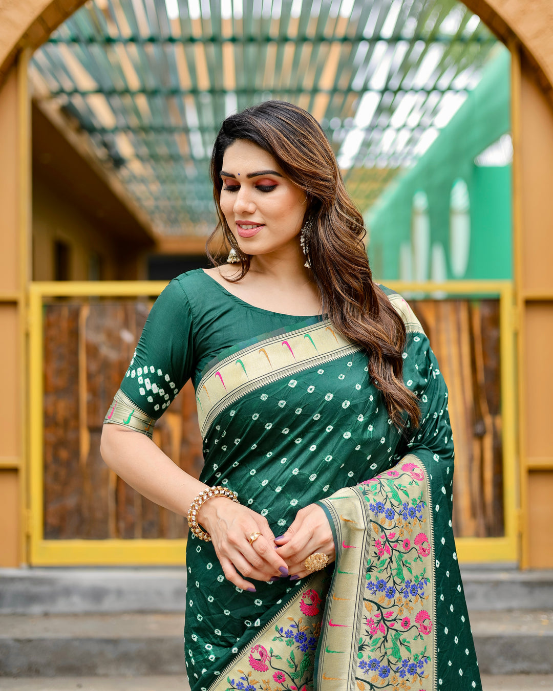 Dark green Bandhej Paithani silk saree with a gorgeous zari border and matching tassels, perfect for weddings or parties.