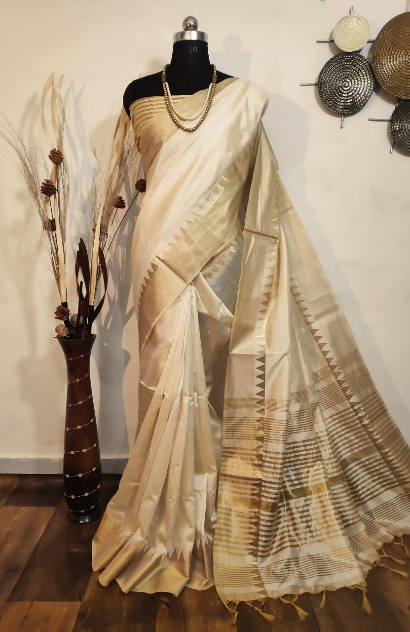 Graceful cream Indian saadi with ornate zari details, perfect for festive occasions and ethnic fashion enthusiasts.