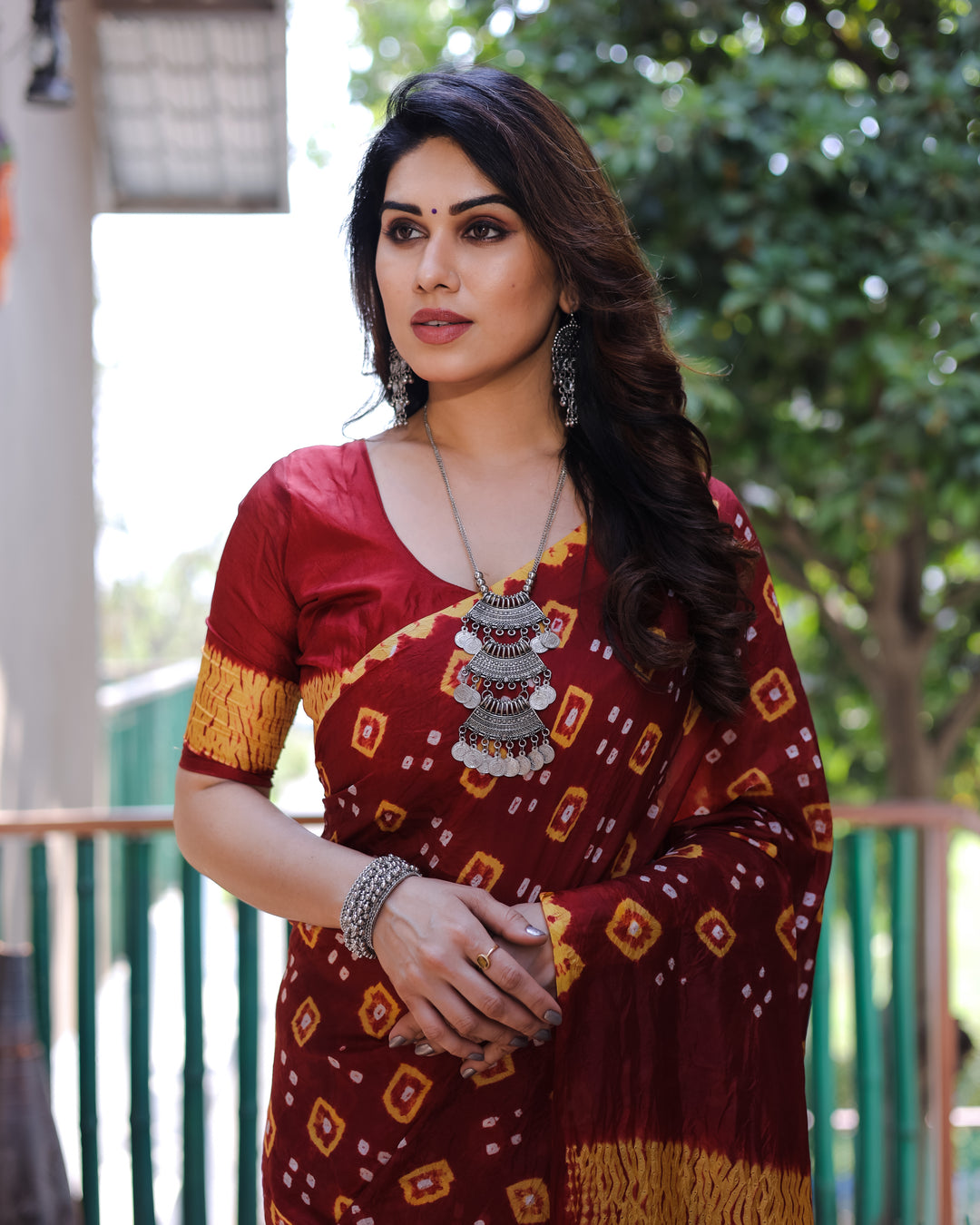 Beautiful maroon Bandhej silk saree with intricate traditional motifs, creating a sophisticated and elegant look.