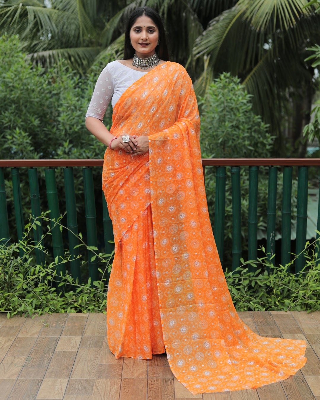 Stunning orange chiffon saree with foil accents, a radiant choice for weddings and parties.