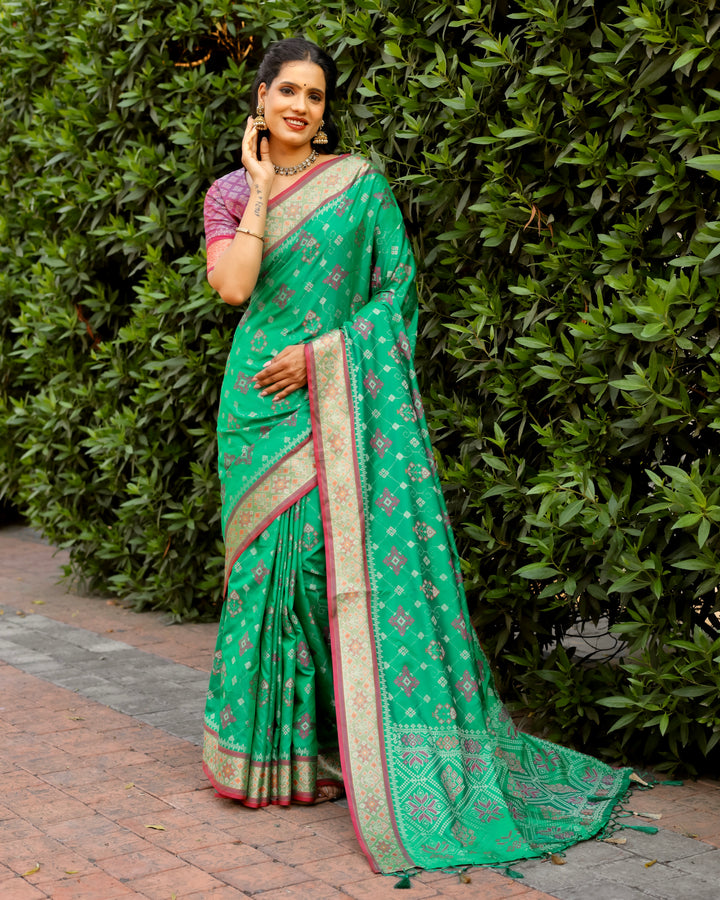 A beautiful mint green Patola silk saree with Kanchi-style borders and intricate Zari work for a sophisticated festive look.