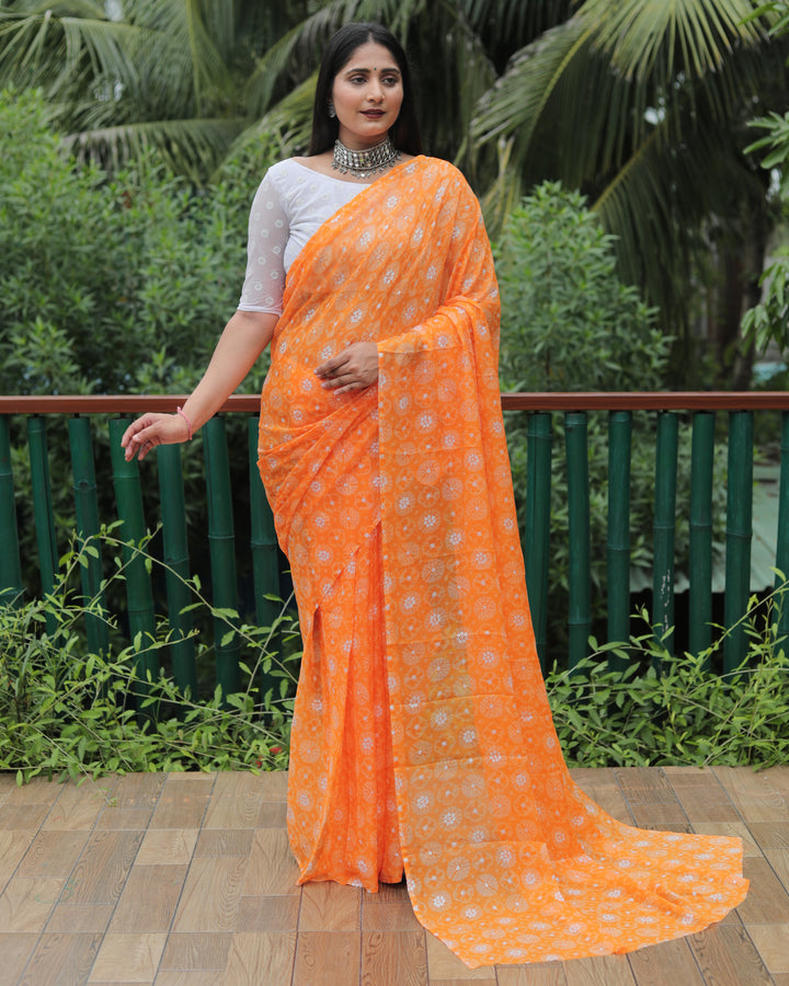 Exquisite orange chiffon saree with foil work, perfect for festive and wedding occasions.