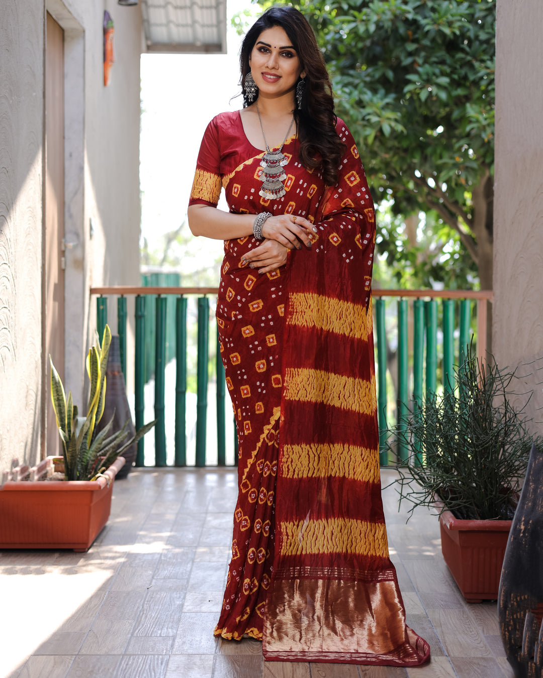 Maroon Bandhej silk saree with a bold and vibrant tissue pallu, crafted for those who love to make a statement.