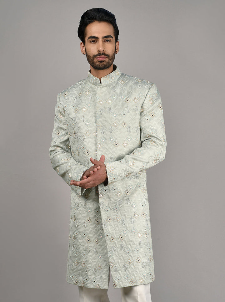 Made from luxurious Jacquard fabric, this Sherwani features exquisite mirror, Resham, and bead embroidery.