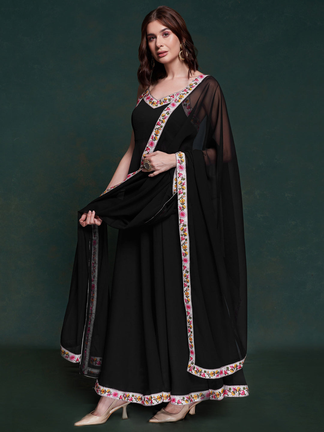 Discover elegance with this exquisite black georgette long suit, featuring intricate lacework that adds a touch of refinement.  The suit is fully stitched and available in sizes XS to XXL, offering a perfect fit and a sophisticated silhouette. Its timeless black color ensures versatility, making it a standout choice for festivals, functions, and special events. The ensemble is completed with matching black georgette pants and a dupatta, adorned with beautiful border lace work.  This coordinated design enhan