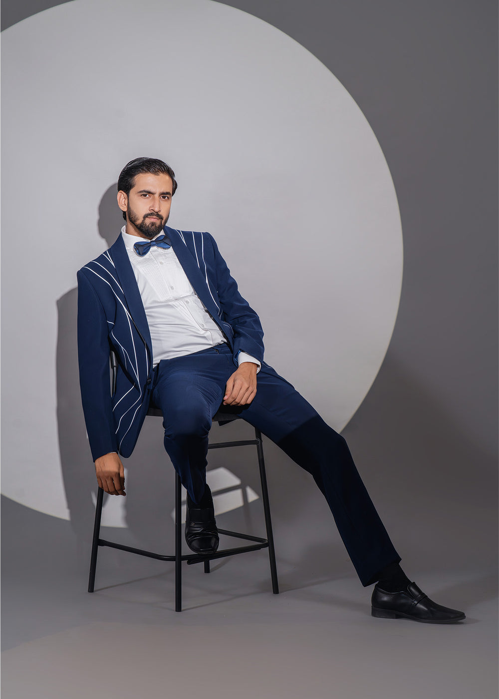 Men’s blue tuxedo with stylish radium lines and white pleated shirt, perfect for weddings and formal celebrations.