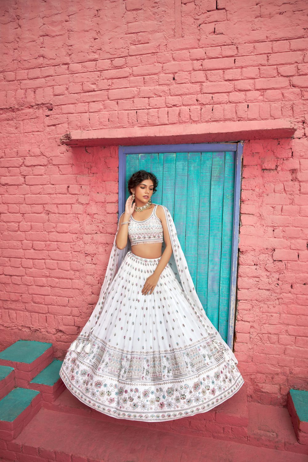 Designer white lehenga with exquisite embroidery, paired with a matching choli for a sophisticated bridal ensemble.