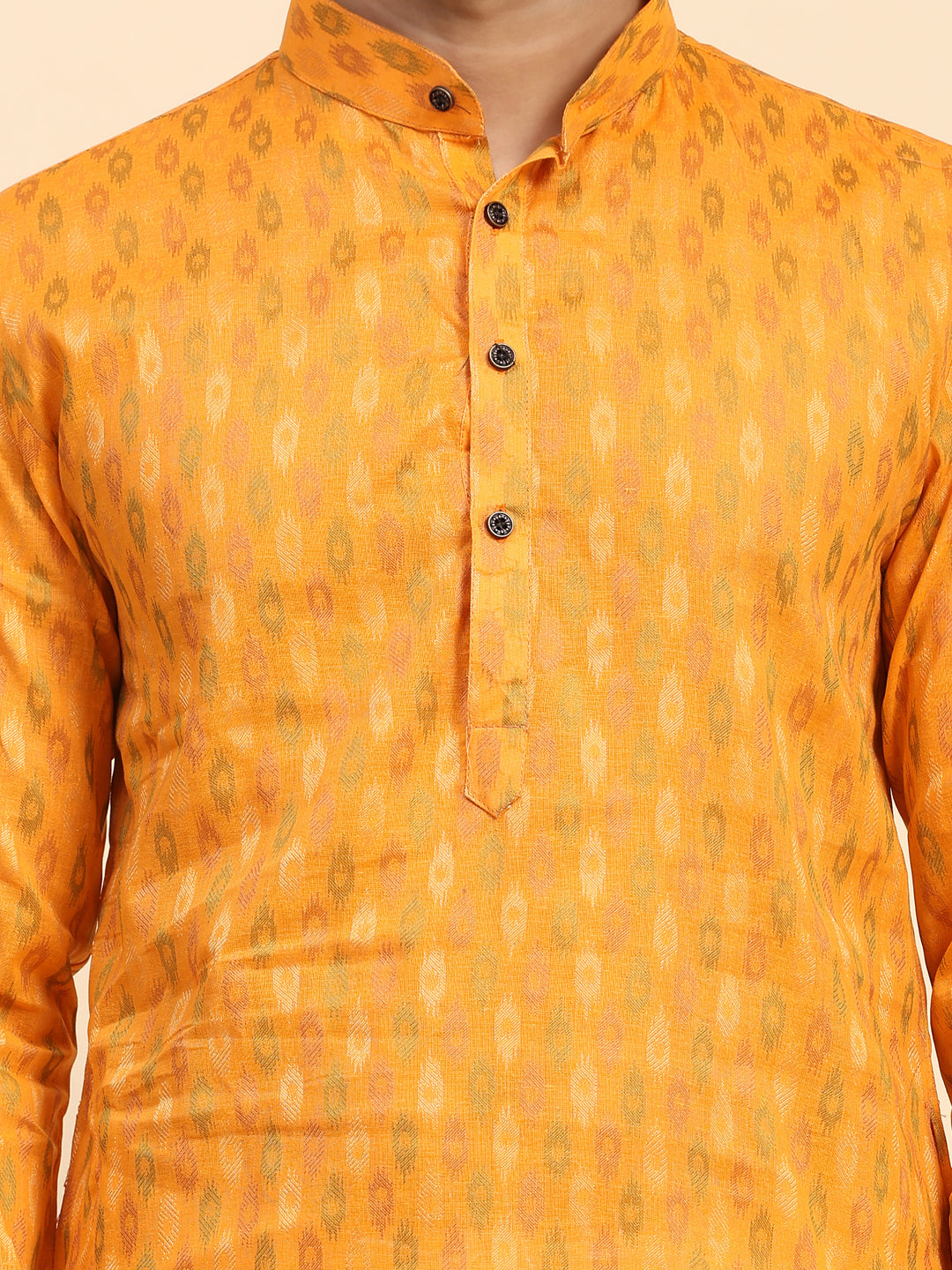 Festive men’s light orange kurta pajama with elegant embroidery on the neckline.