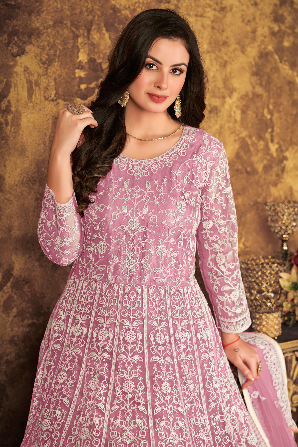 Elegant net fabric salwar kameez in pink, showcasing exquisite detailing for weddings and special occasions.