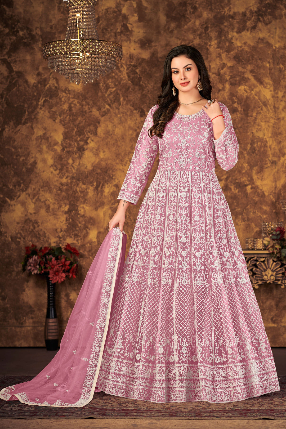 Beautiful pink salwar kameez crafted from net fabric, ideal for special occasions and festive celebrations.