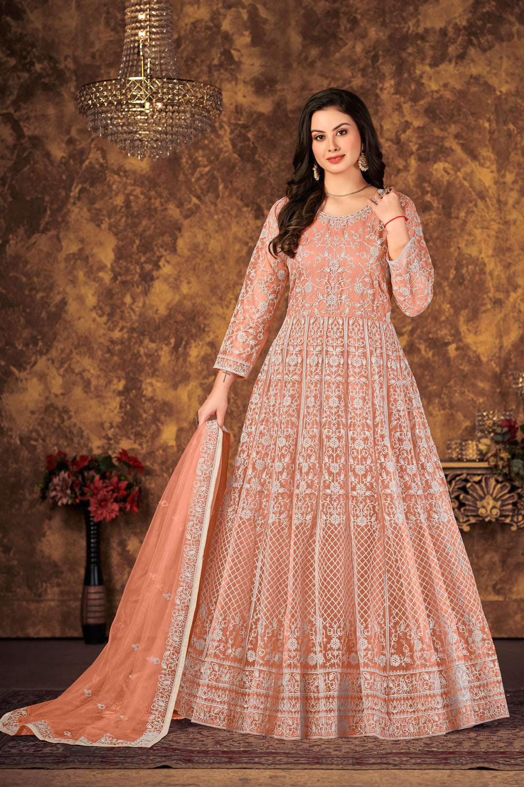 Embrace elegance with peach salwar kameez, crafted from soft net fabric, perfect for celebrations.