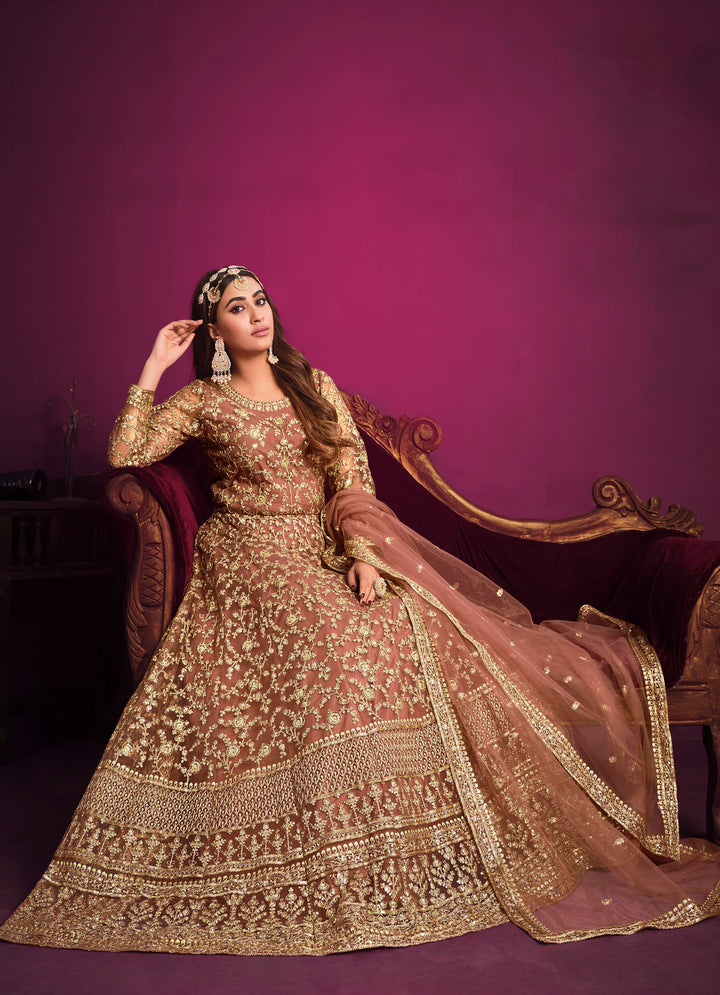 Exude charm in coral salwar kameez featuring a stunning net set with a delicate dupatta, perfect for festive occasions.