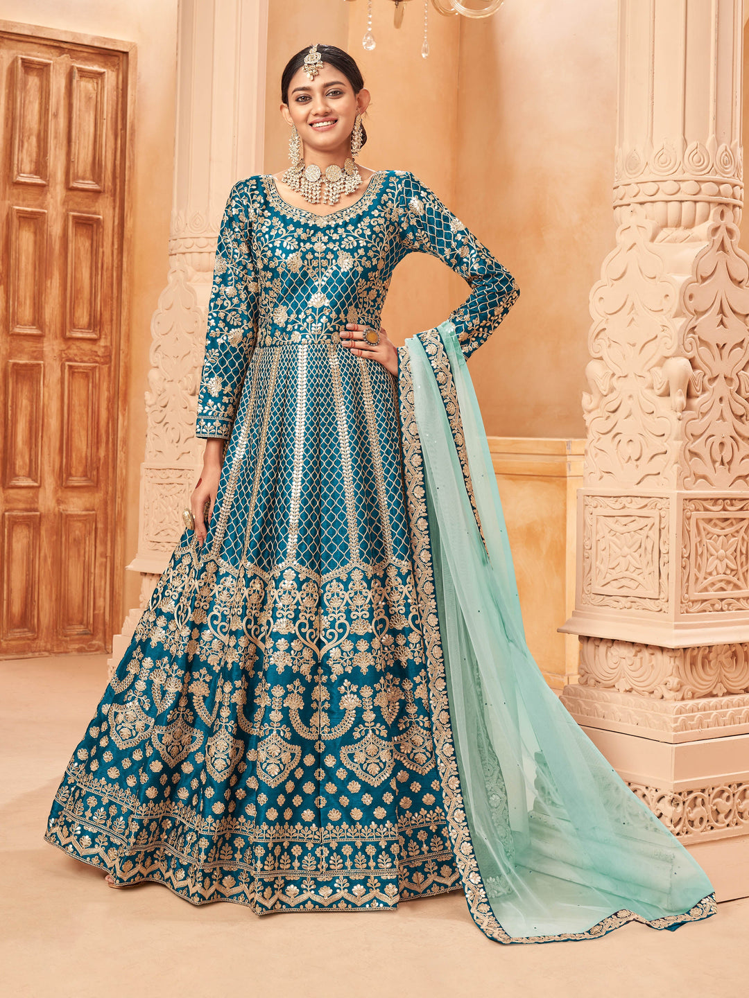 Teal blue art silk salwar kameez featuring heavy thread embroidery with zari work, ideal for festive occasions.