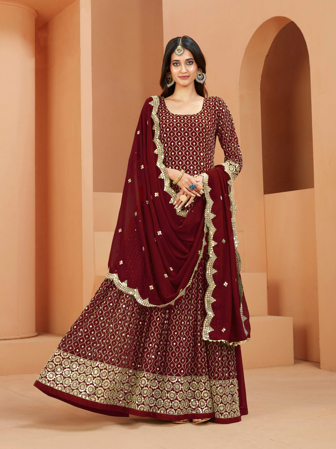 Maroon faux georgette salwar kameez featuring heavy thread embroidery with zari and sequins work.