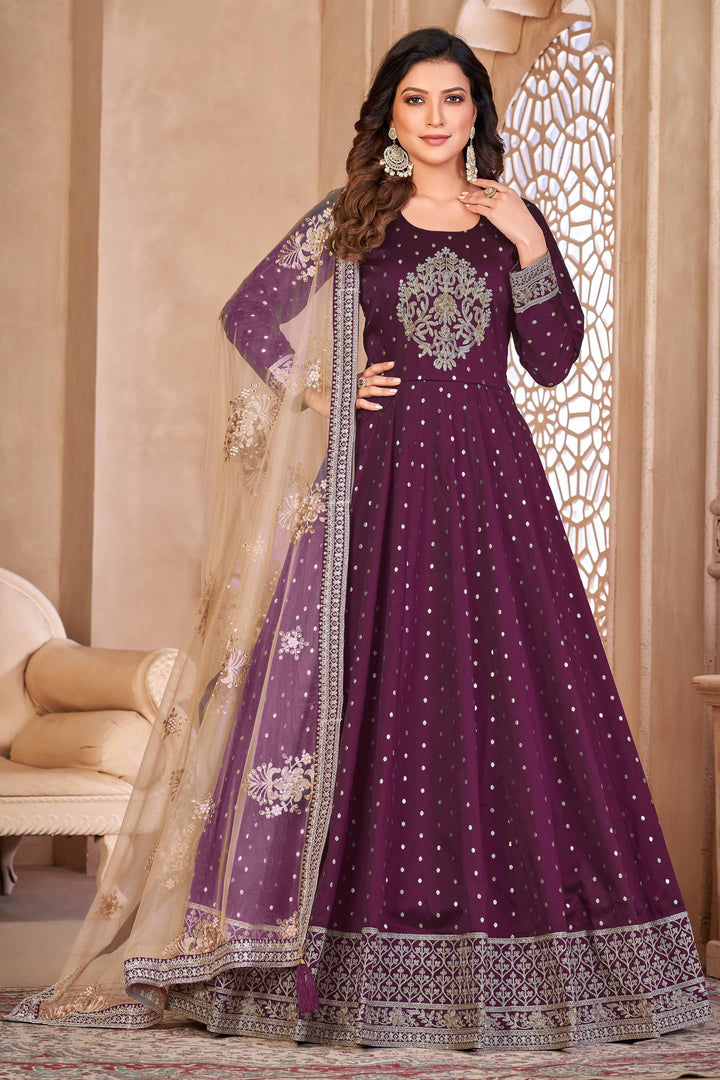 Wine taffeta salwar kameez featuring butti design with heavy thread embroidery and sequins work.