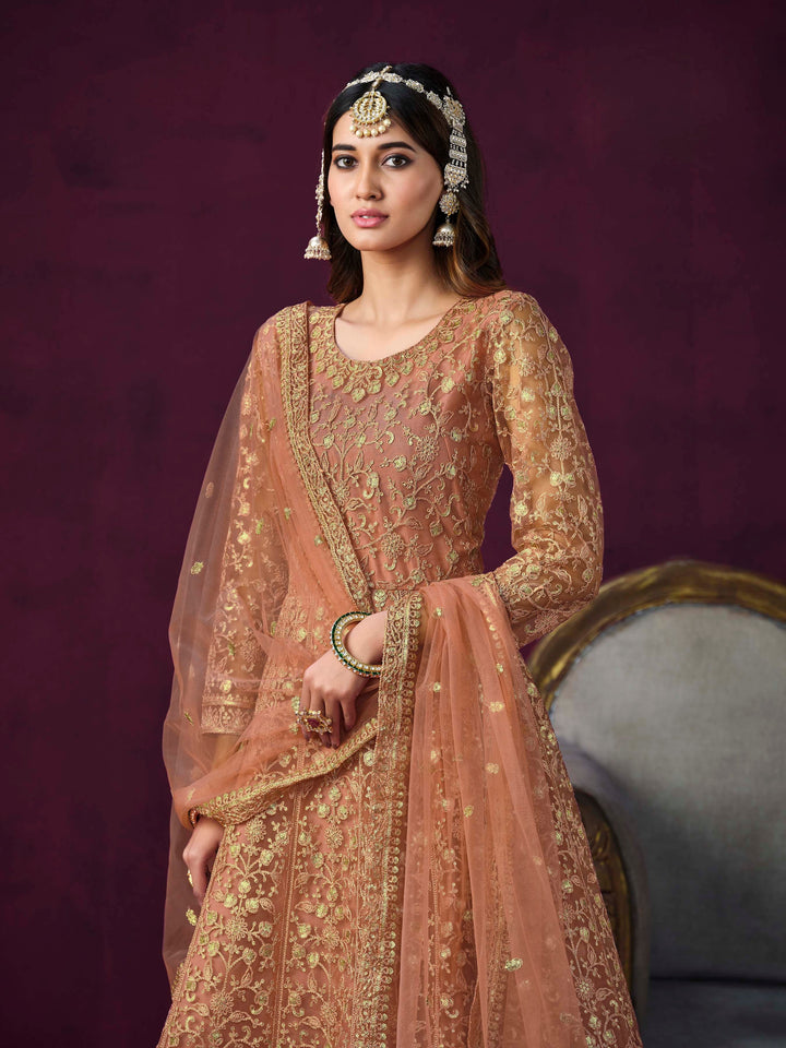 Luxurious coral salwar kameez showcasing exquisite detailing for weddings and events.