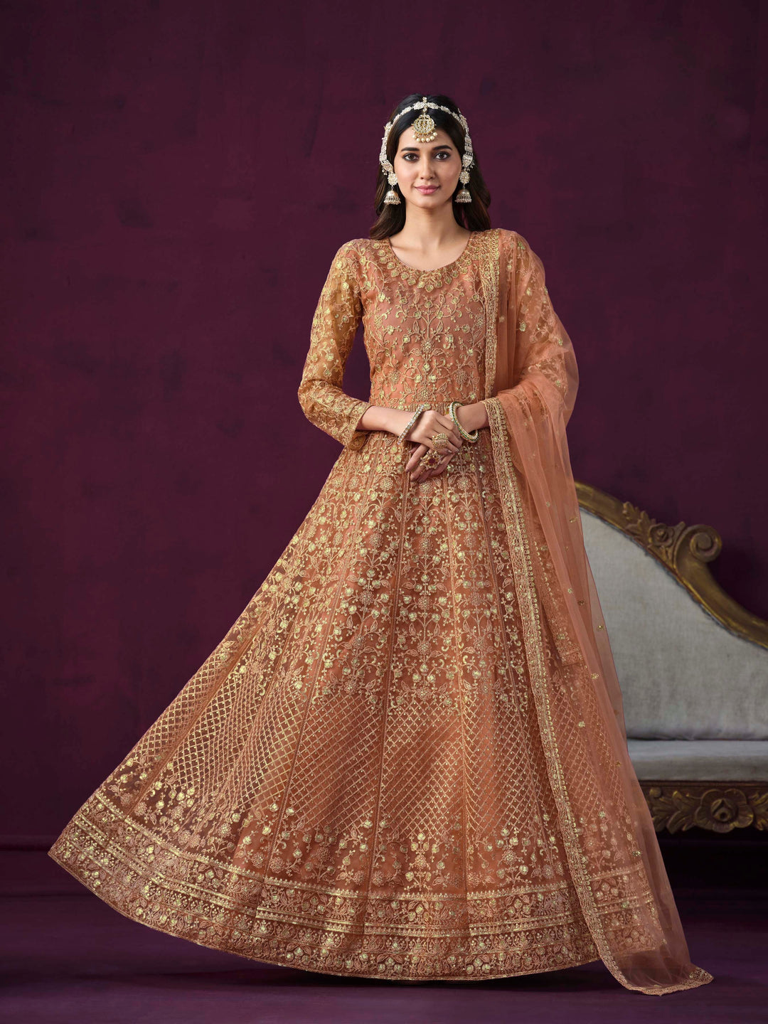 Coral net salwar kameez featuring heavy thread embroidery with zari and sequins work.