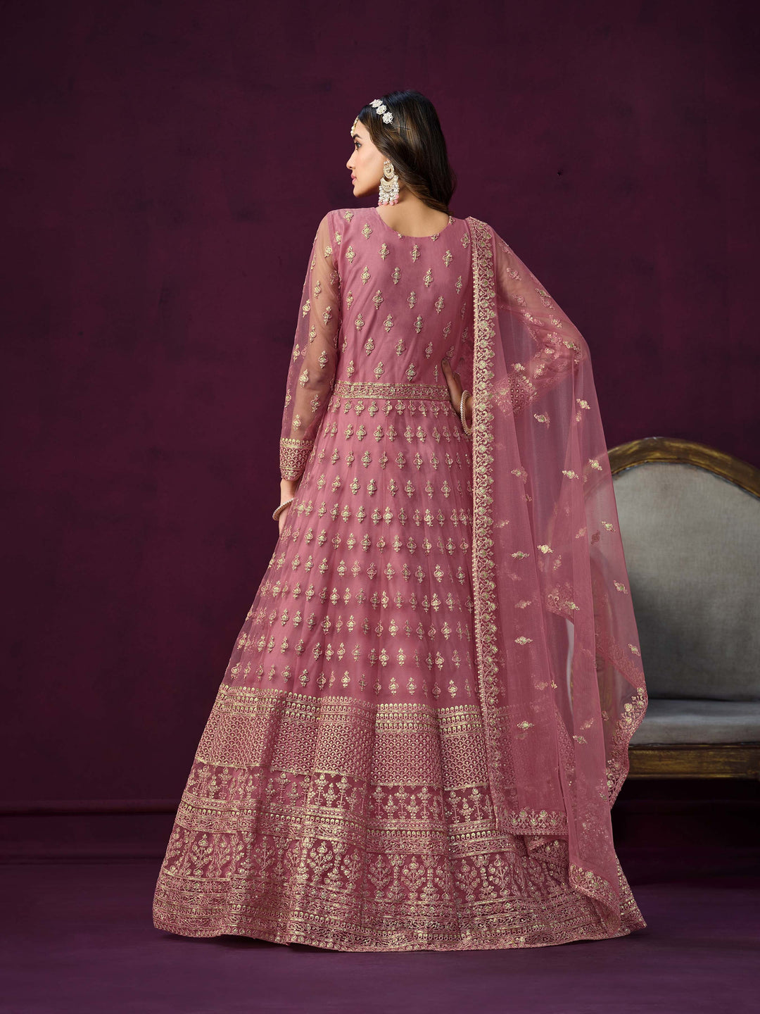 Stylish pink net salwar kameez with intricate embroidery and zari work, ideal for festive occasions.