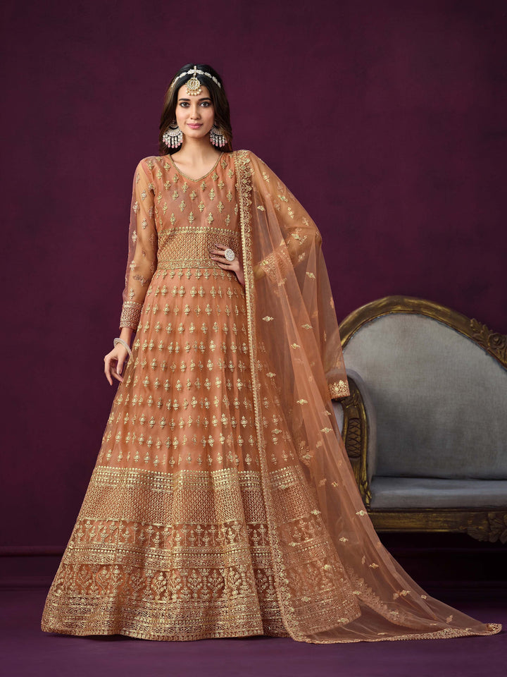 Coral net salwar kameez featuring heavy thread embroidery with zari and sequins work.