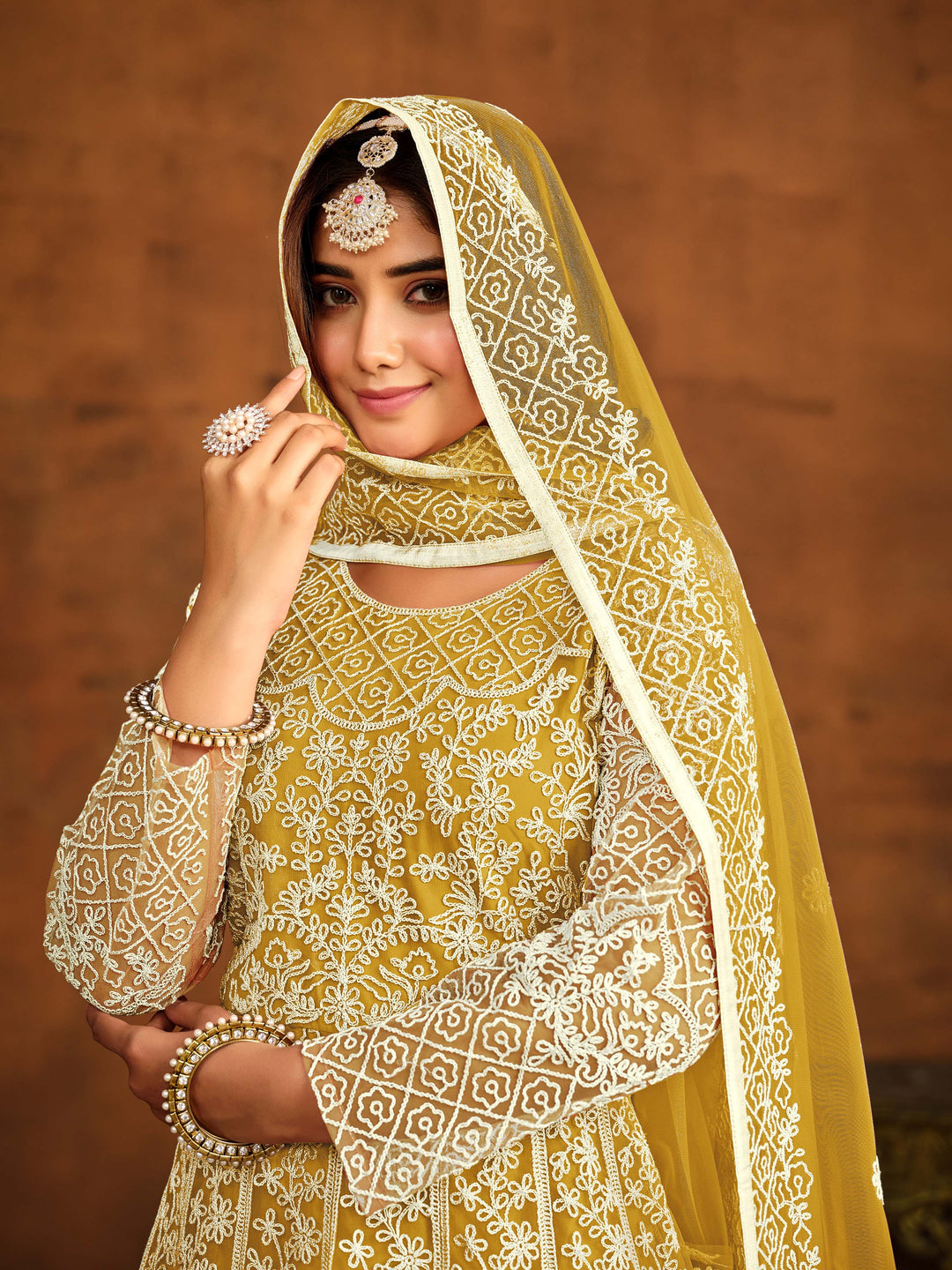 Chic yellow net salwar kameez with heavy embroidery work, ideal for special occasions.