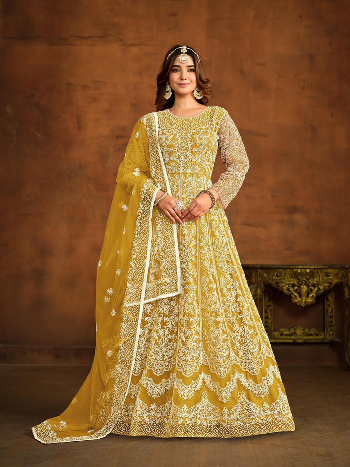 Yellow net salwar kameez featuring heavy thread embroidery work.