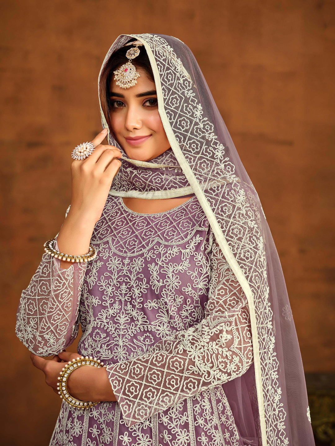 Chic light purple net salwar kameez with heavy embroidery work, ideal for special occasions.