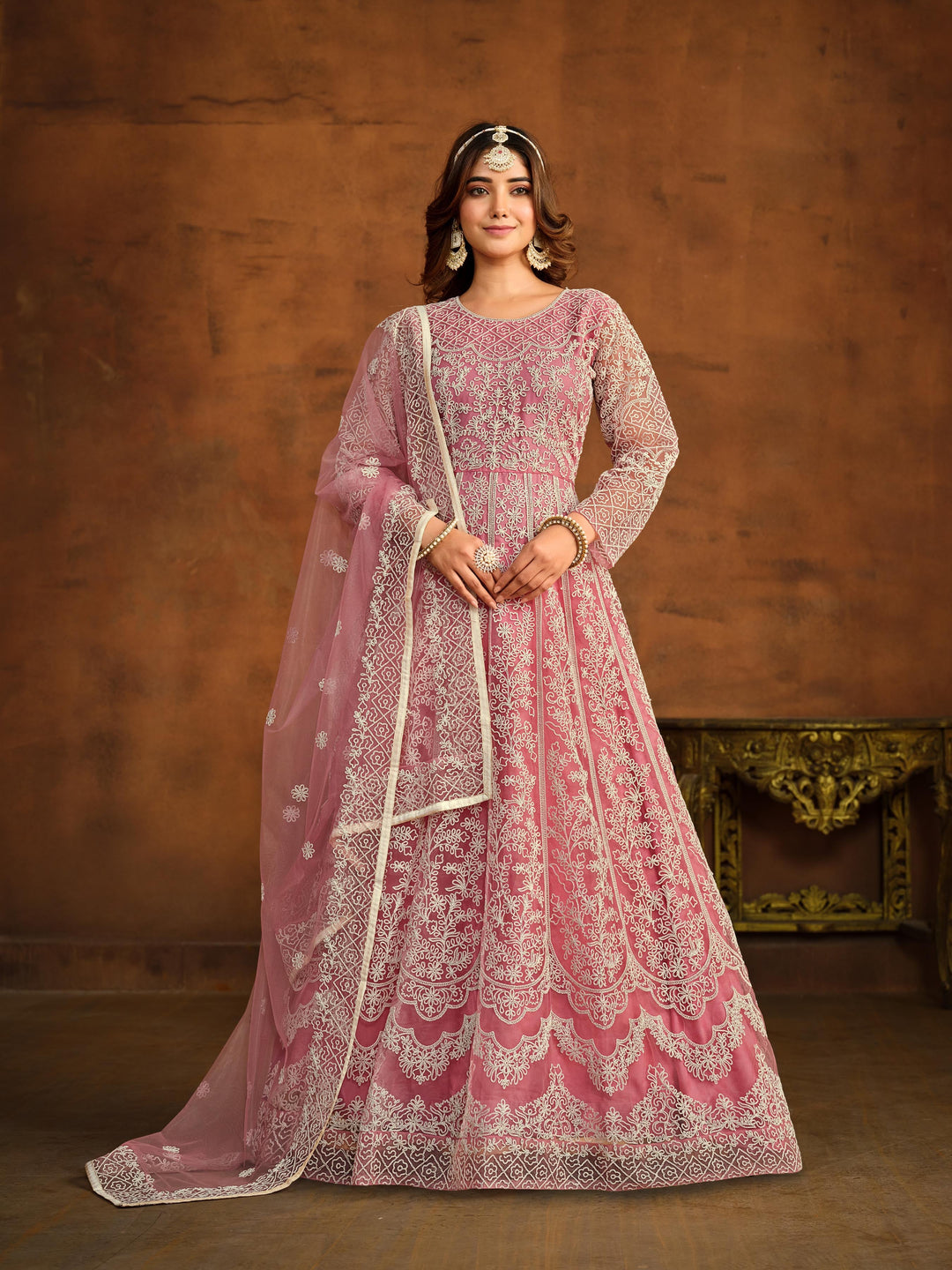 Pink net salwar kameez featuring heavy thread embroidery work.