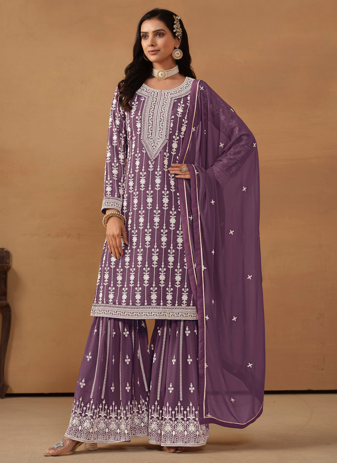 Stunning purple salwar kameez in faux georgette featuring intricate thread embroidery and shimmering sequins.