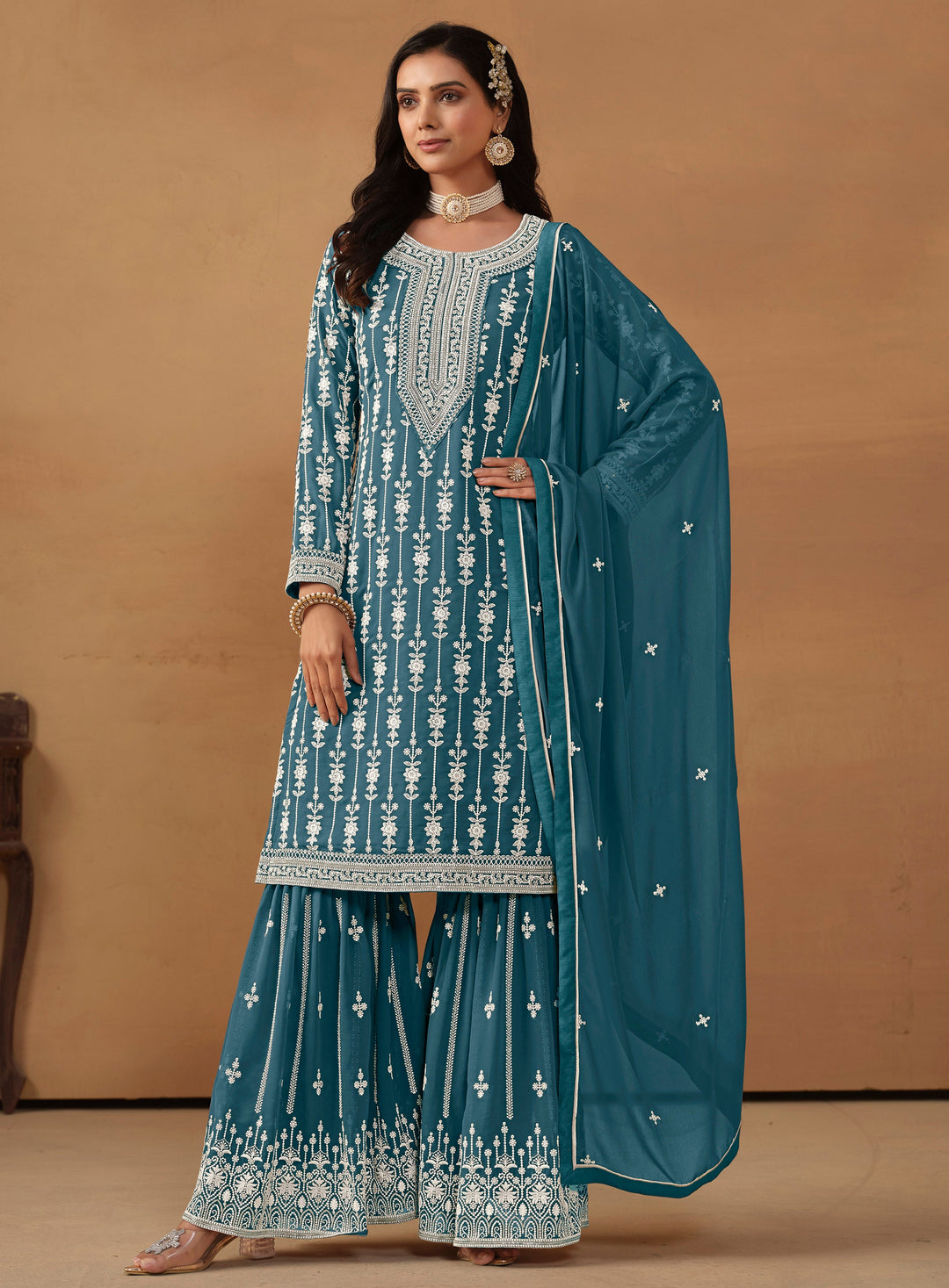 Stunning teal salwar kameez in faux georgette featuring intricate thread embroidery and sparkling sequins for special events.