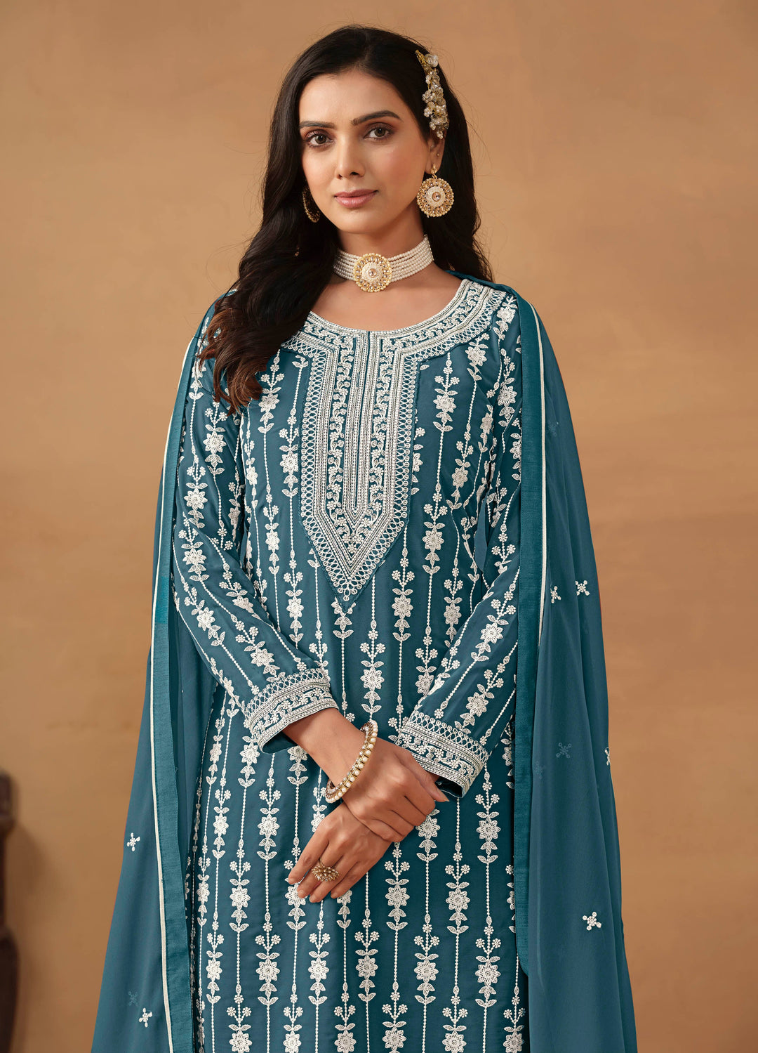 Luxurious teal faux georgette salwar kameez adorned with heavy embroidery and sequins, ideal for weddings and celebrations.