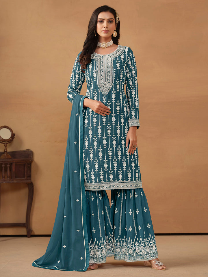 Elegant teal faux georgette salwar kameez with heavy thread embroidery and sequin work, perfect for festive occasions.