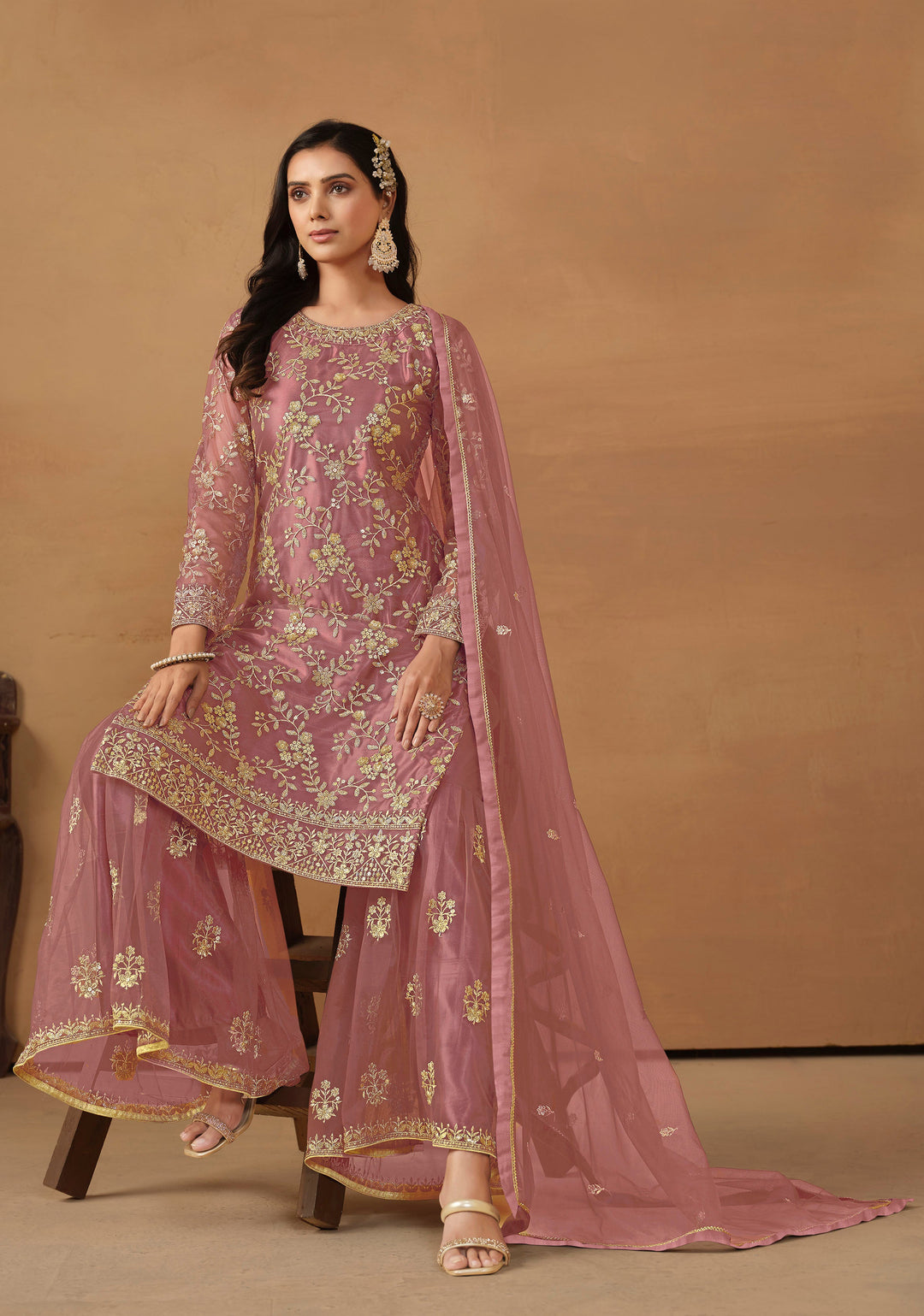 Beautiful dusty pink salwar kameez crafted from net, showcasing intricate heavy thread and sequin embellishments.