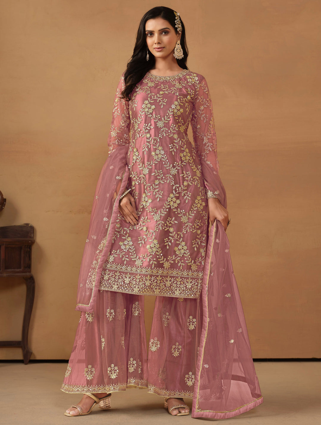 Elegant dusty pink net salwar kameez featuring heavy thread embroidery and sequins, perfect for special occasions.