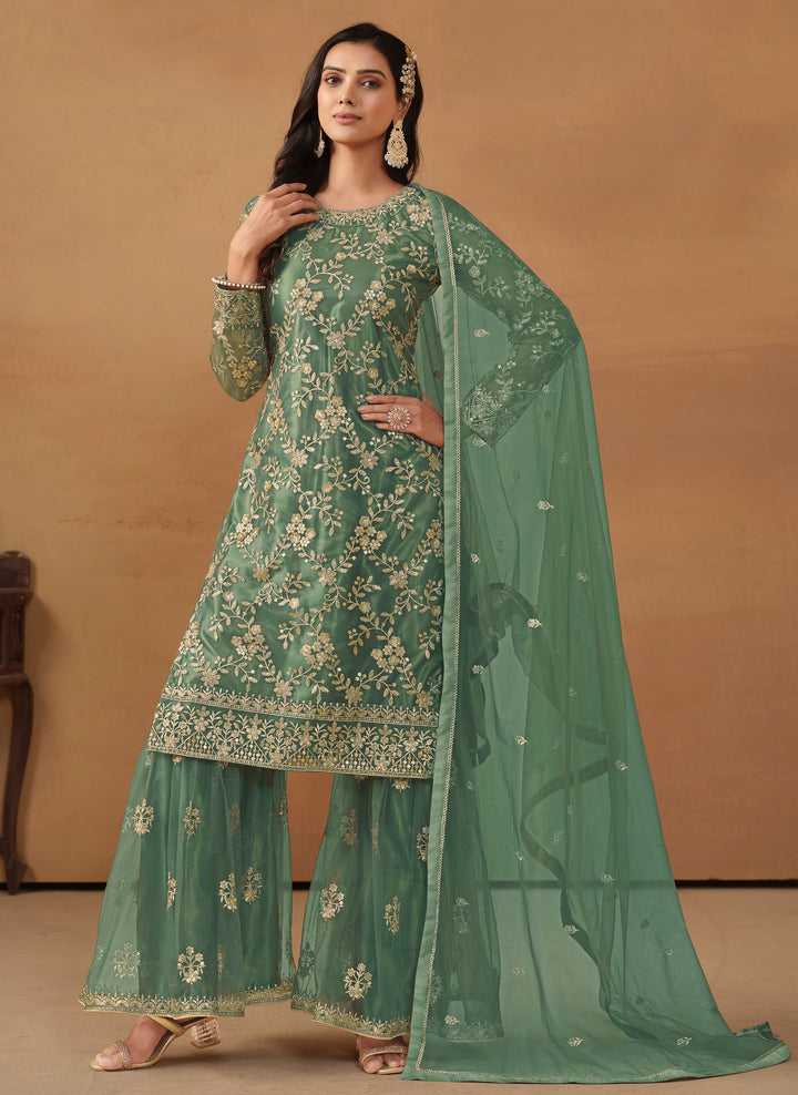 Stunning rama green salwar kameez in net with intricate thread embroidery and shimmering sequin work for special events.