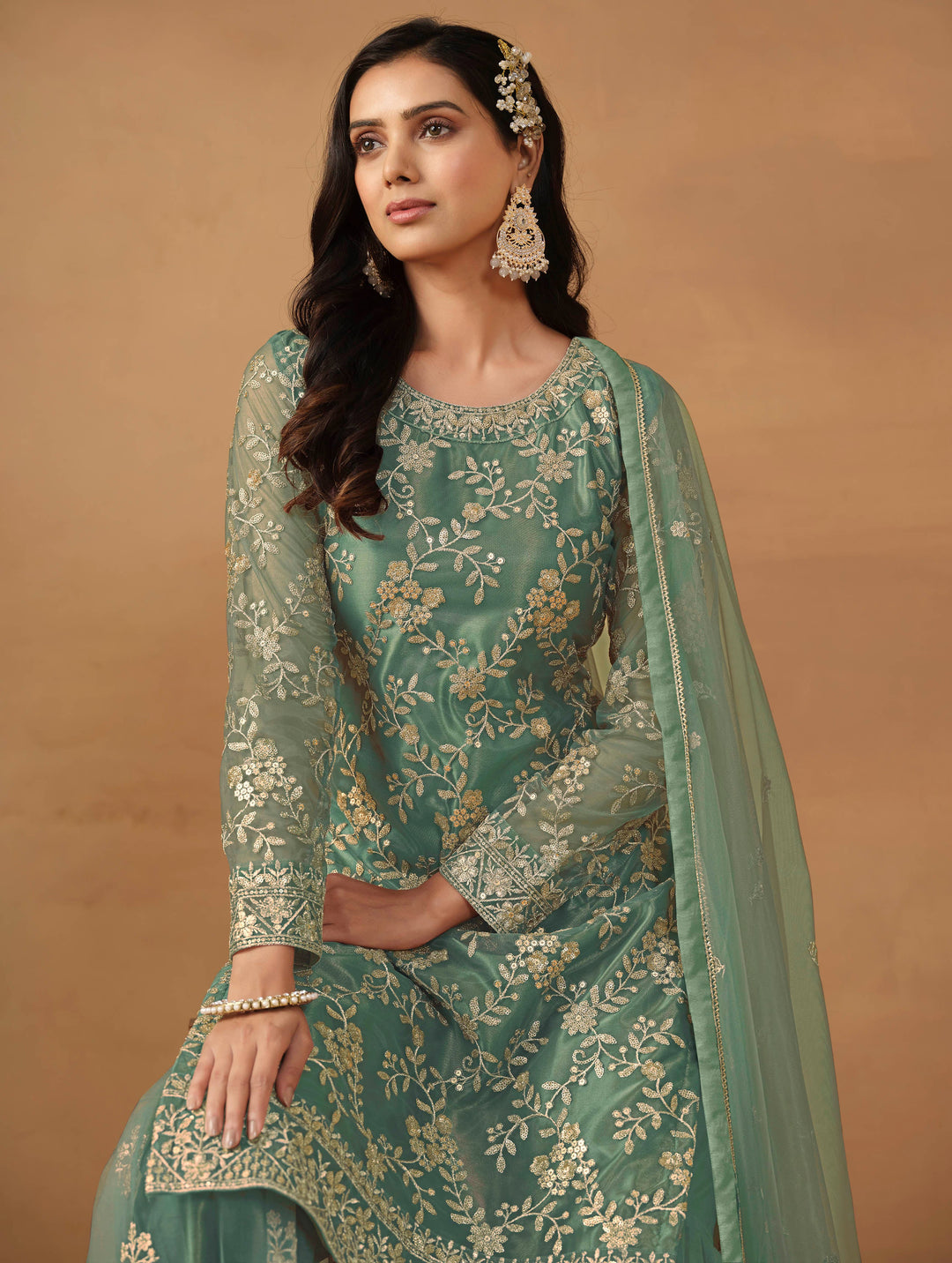 Luxurious rama green net salwar kameez adorned with exquisite heavy embroidery and sequins, ideal for weddings and celebrations.