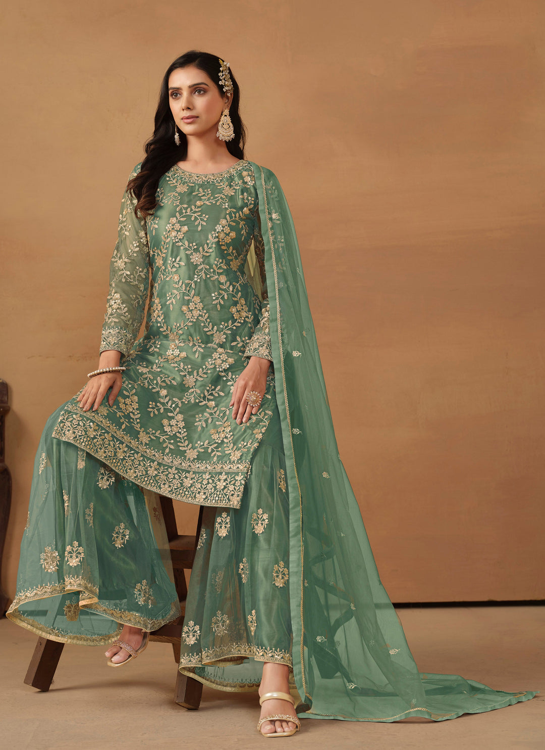 Beautiful rama green salwar kameez crafted from net, showcasing intricate heavy thread and sequin embellishments.