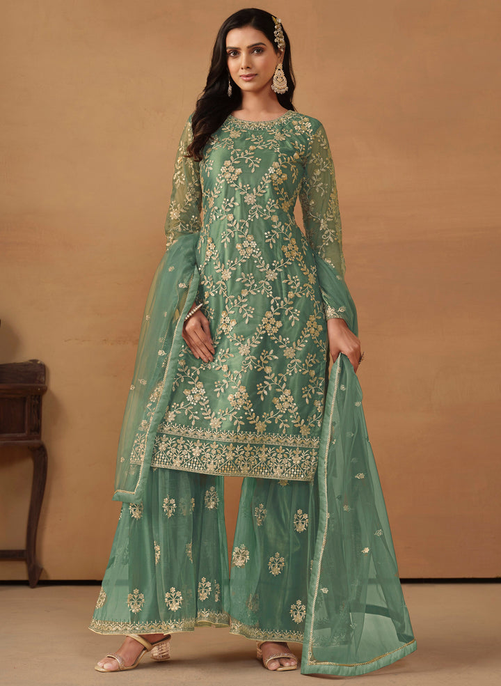 Elegant rama green net salwar kameez featuring heavy thread embroidery and sequins, perfect for festive occasions.