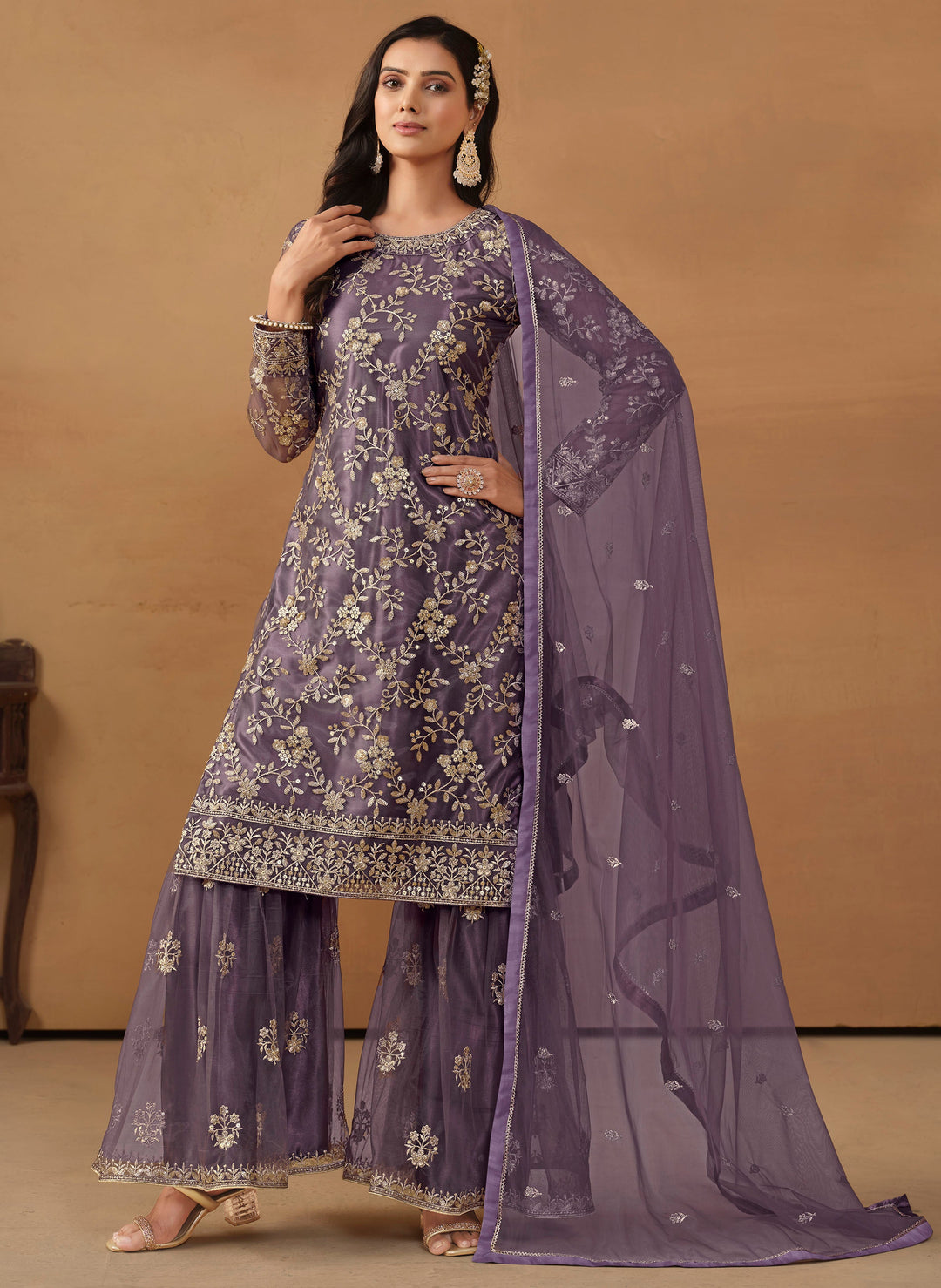 Stunning purple salwar kameez in net with intricate thread embroidery and shimmering sequin work for special events.