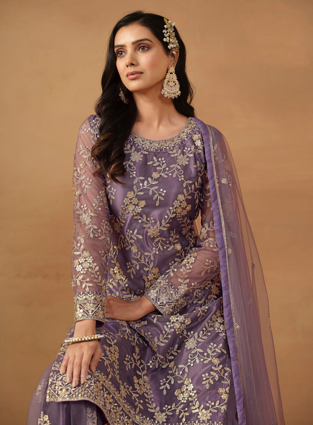 Luxurious purple net salwar kameez adorned with exquisite heavy embroidery and sequins, ideal for weddings and celebrations.