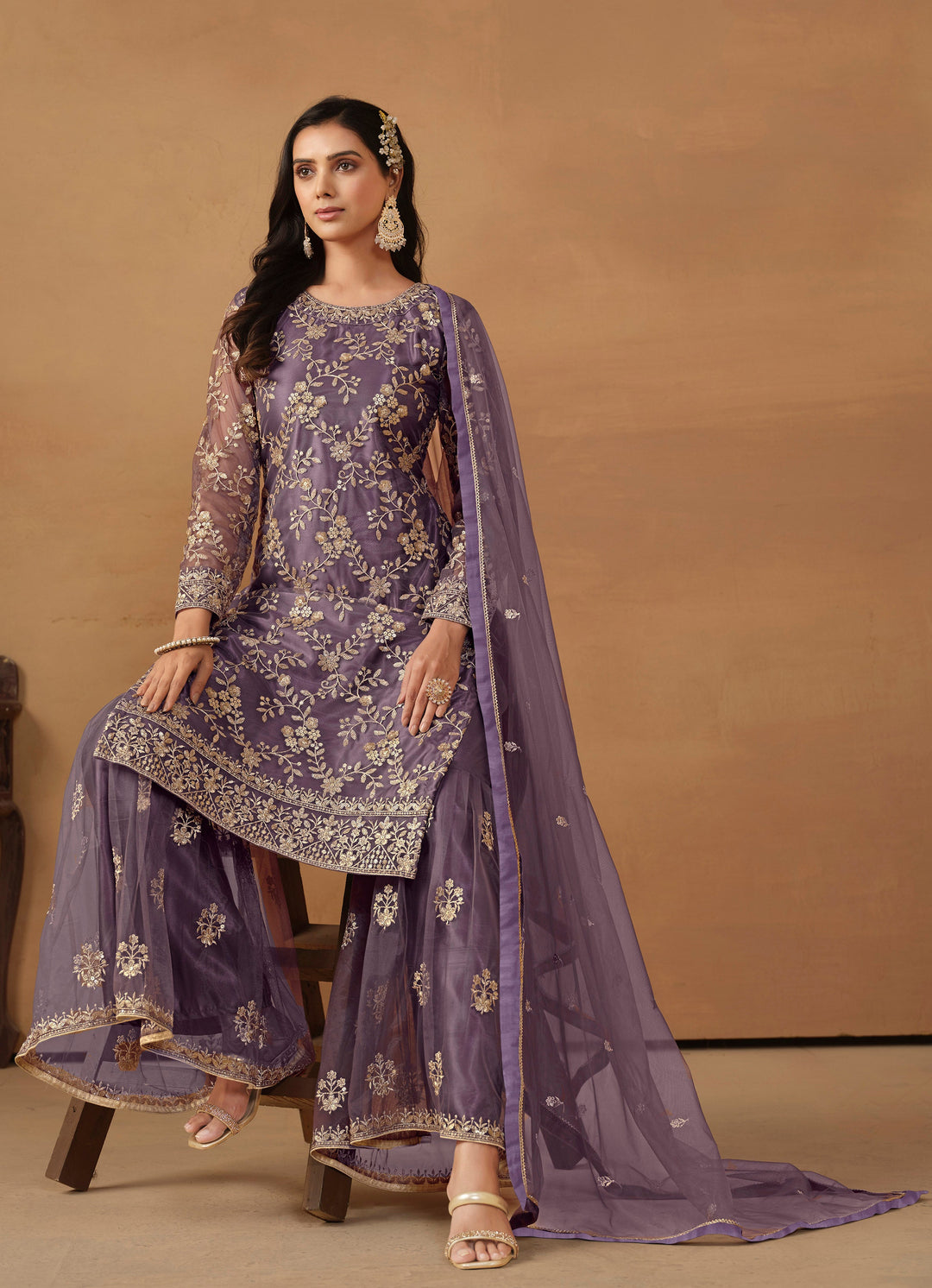 Beautiful purple salwar kameez crafted from net, showcasing intricate heavy thread and sequin embellishments.