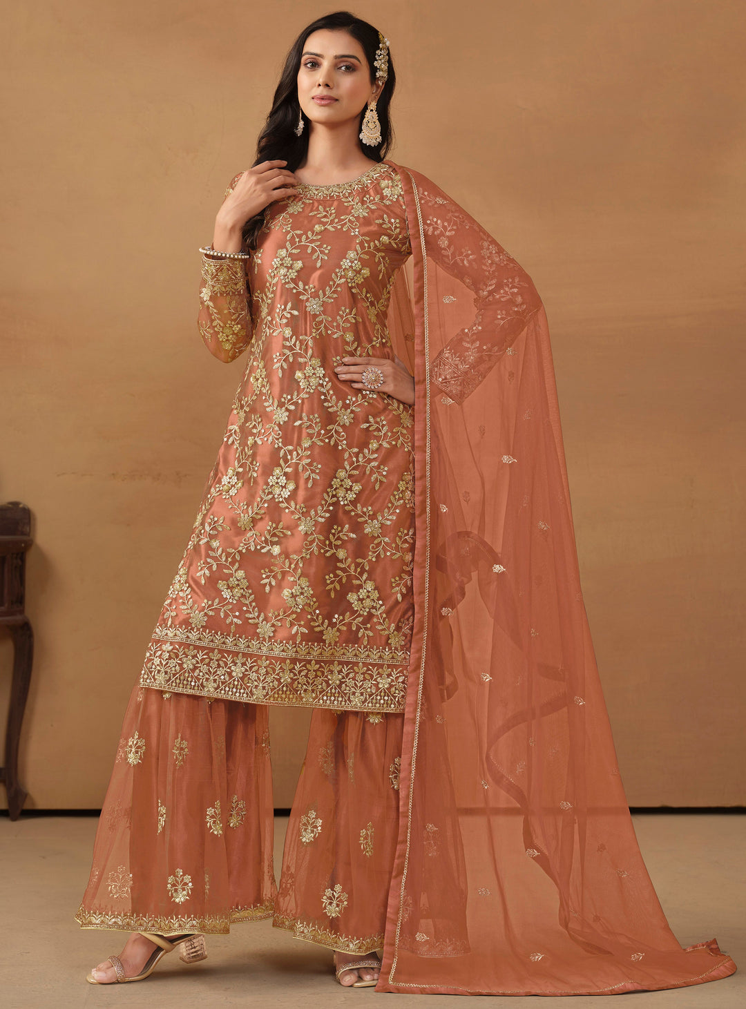 Stunning dark salmon salwar kameez in net with intricate thread embroidery and shimmering sequin work for special events.