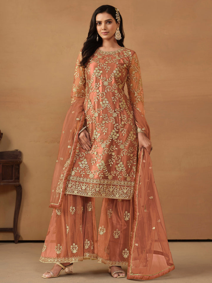 Elegant dark salmon net salwar kameez featuring heavy thread embroidery and sequins, perfect for festive occasions.