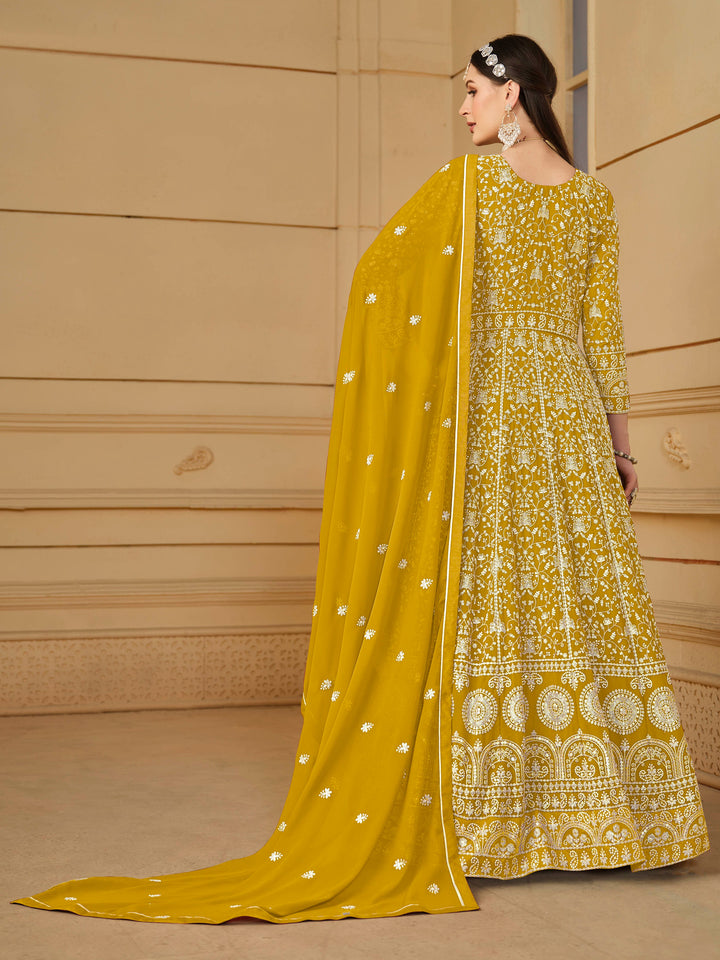 Luxurious mustard faux georgette salwar kameez adorned with exquisite heavy embroidery and sequins, ideal for weddings.