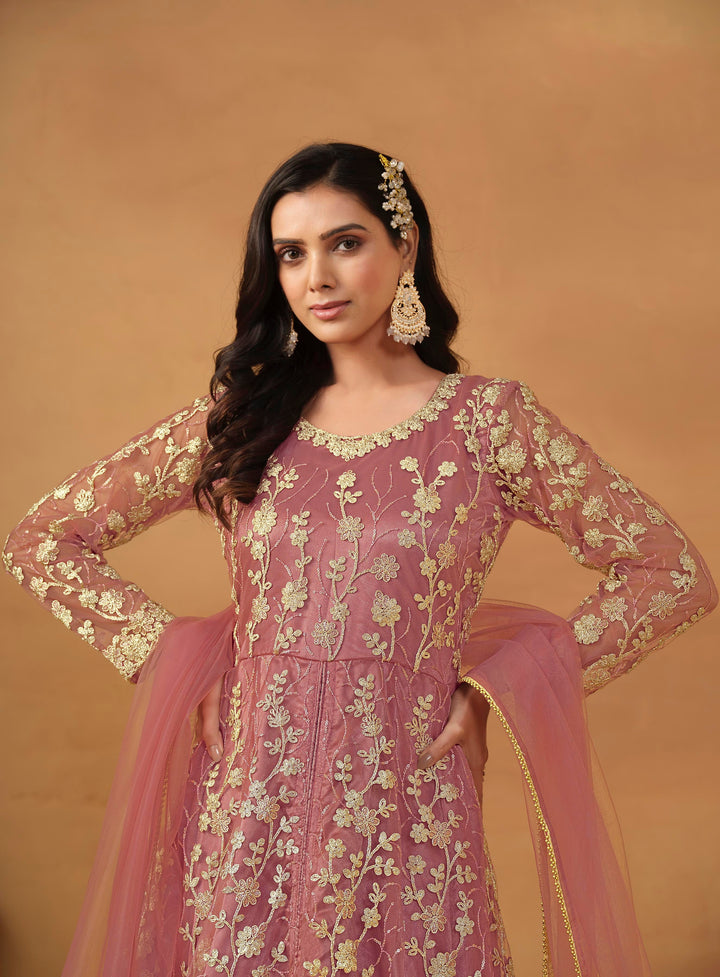 Stunning dusty pink salwar kameez in net with intricate thread embroidery and shimmering sequin work for festive events.