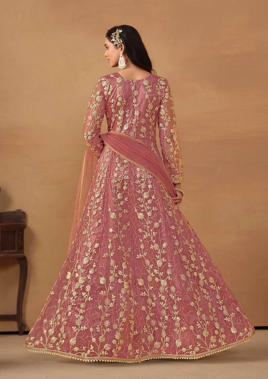 Luxurious dusty pink net salwar kameez adorned with exquisite heavy embroidery and sequins, ideal for weddings and celebrations.