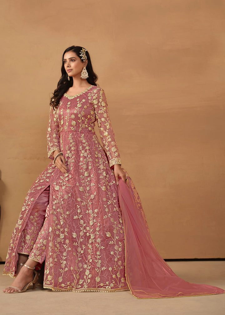 Beautiful dusty pink salwar kameez crafted from net, showcasing intricate heavy thread and sequin embellishments.