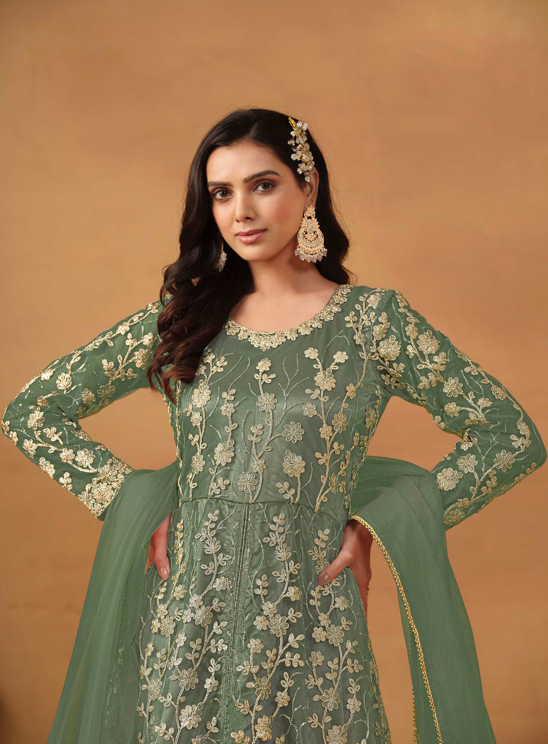 Stunning sage green salwar kameez in net with intricate thread embroidery and shimmering sequin work for festive events.