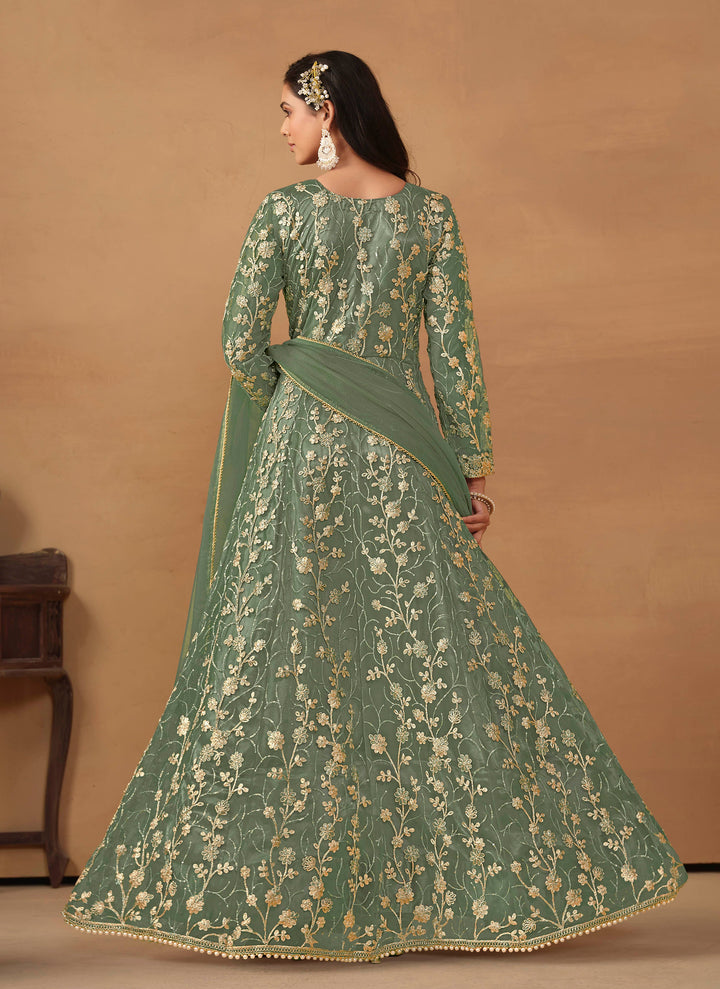 Luxurious sage green net salwar kameez adorned with exquisite heavy embroidery and sequins, ideal for weddings and celebrations.