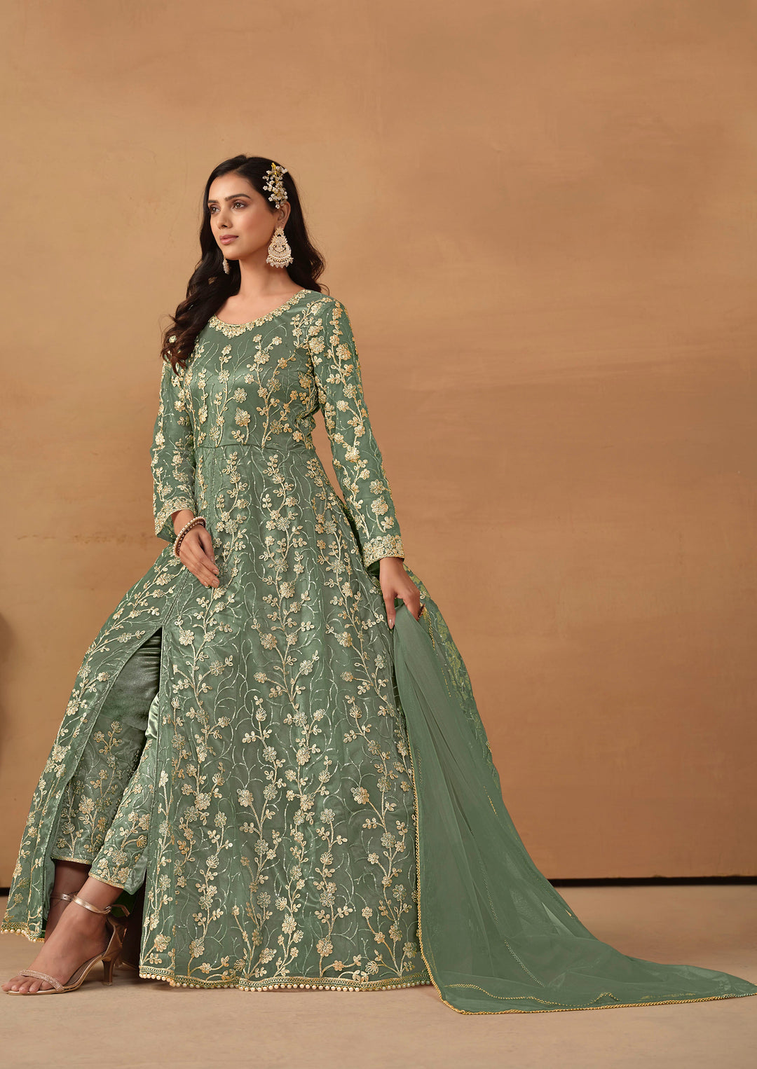 Beautiful sage green salwar kameez crafted from net, showcasing intricate heavy thread and sequin embellishments.