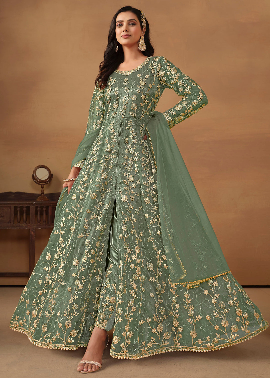 Elegant sage green net salwar kameez featuring heavy thread embroidery and sequins, perfect for special occasions.